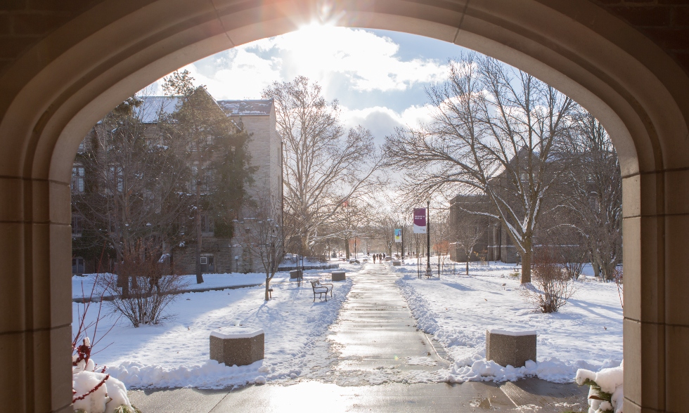 A view of campus looking out of the doorframe of the University Club in the winter.